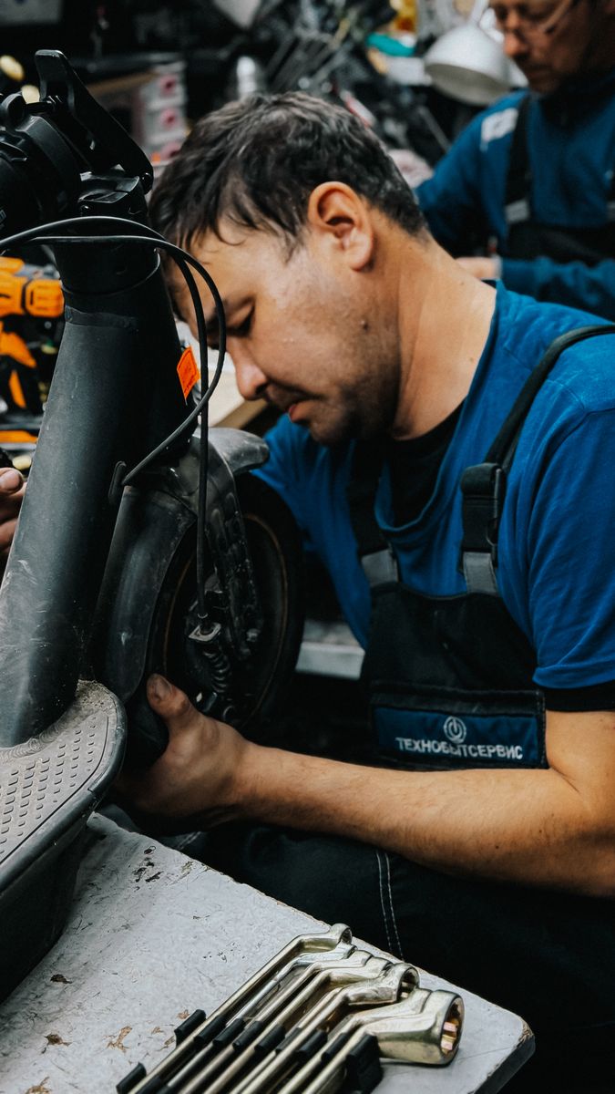 Technik v dílně opravuje elektrokoloběžku